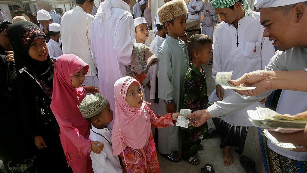 أطفال يتلقون العيدية.