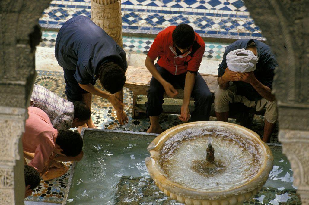 صورة لأفراد أثناء الوضوء من حوض في جامع القرويين
