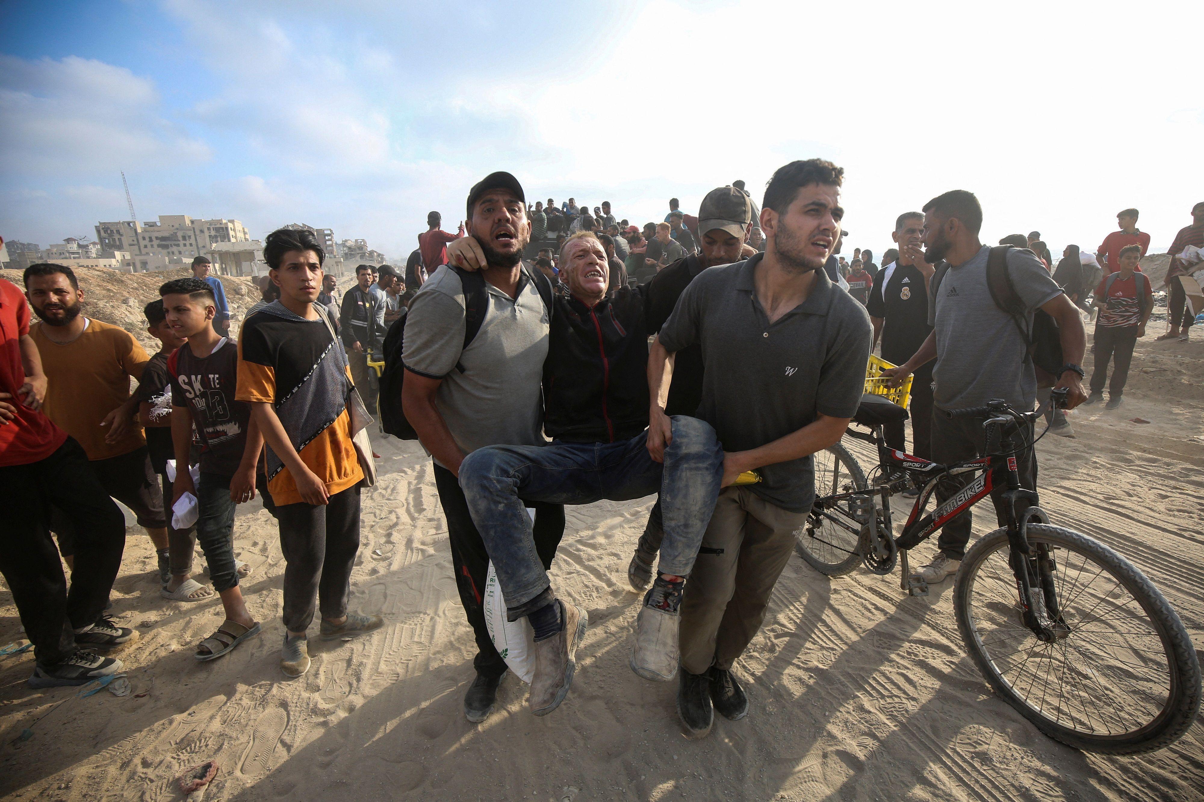 فلسطينيون يحملون رجلاً مصاباً في بيت لاهيا، شمال قطاع غزة، 22 يونيو/حزيران 2025