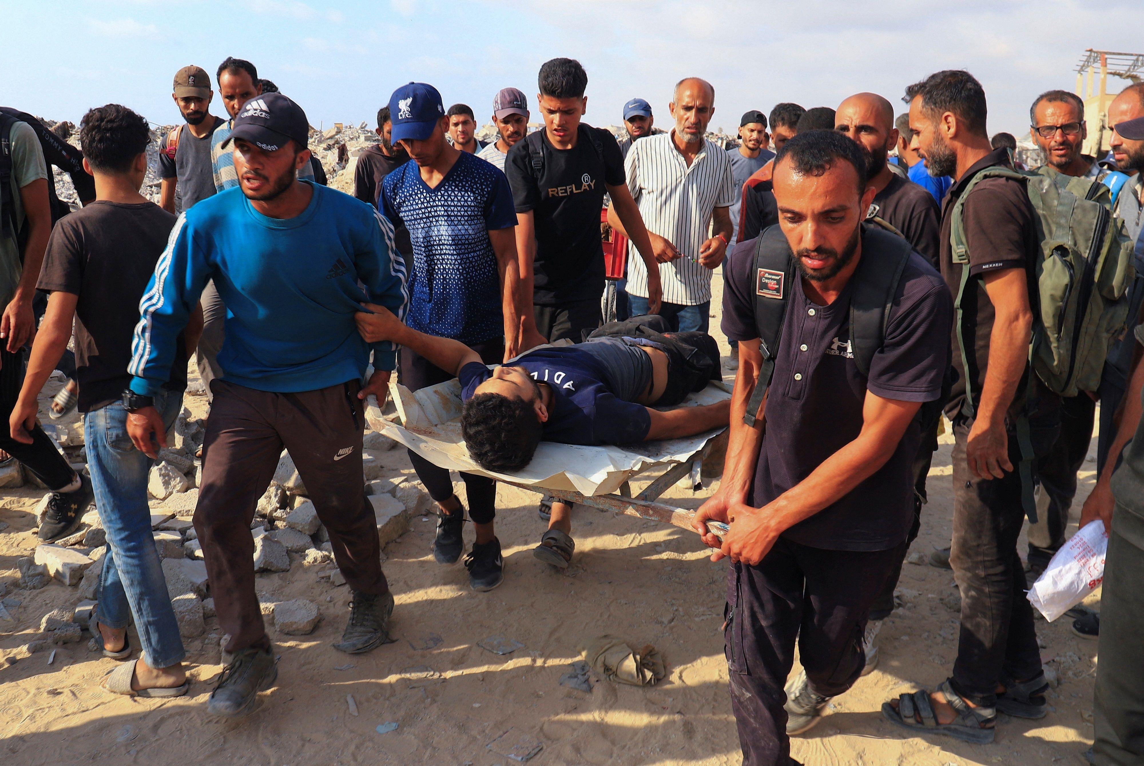 فلسطينيون يحملون رجلاً مصاباً في بيت لاهيا، شمال قطاع غزة، 23 يونيو/حزيران 2025