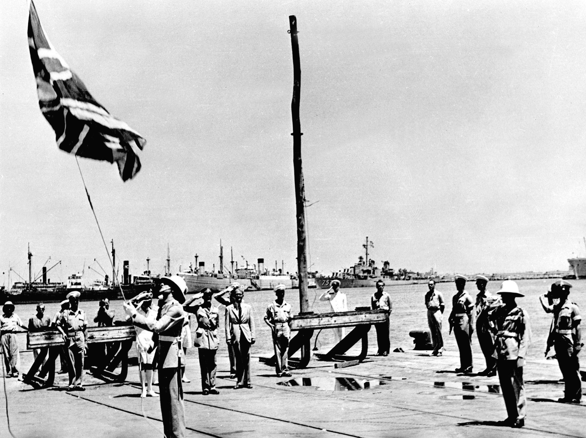 أحد أفراد الجيش البريطاني ينزل علم بلاده للمرة الأخيرة في 30 يونيو/حزيران 1948 في ميناء حيفا