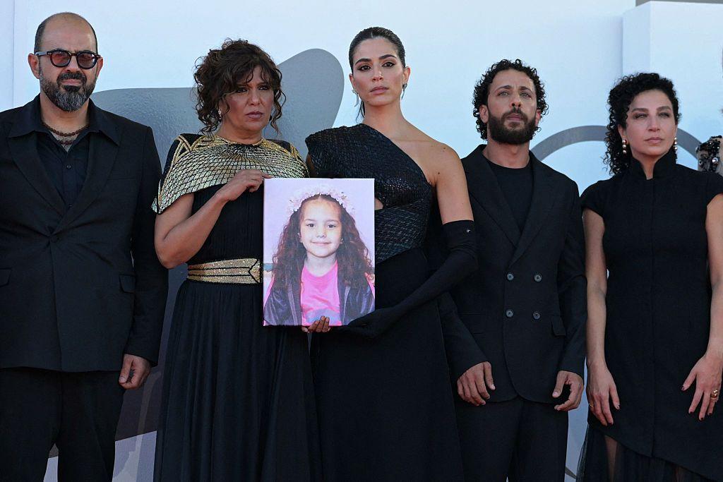 من اليسار: الممثل عامر حليحل، المخرجة كوثر بن هنية، الممثلة سجى كيلاني، الممثل معتز ملحيس، والممثلة كلارا خوري، يقفون أمام صورة الفتاة الفلسطينية هند رجب على السجادة الحمراء لفيلم 