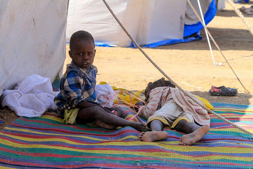 أطفال من الفاشر يستريحون خارج خيمتهم في مخيم للنازحين السودانيين في بلدة الدبة الشمالية، 13 نوفمبر/تشرين الثاني 2025.