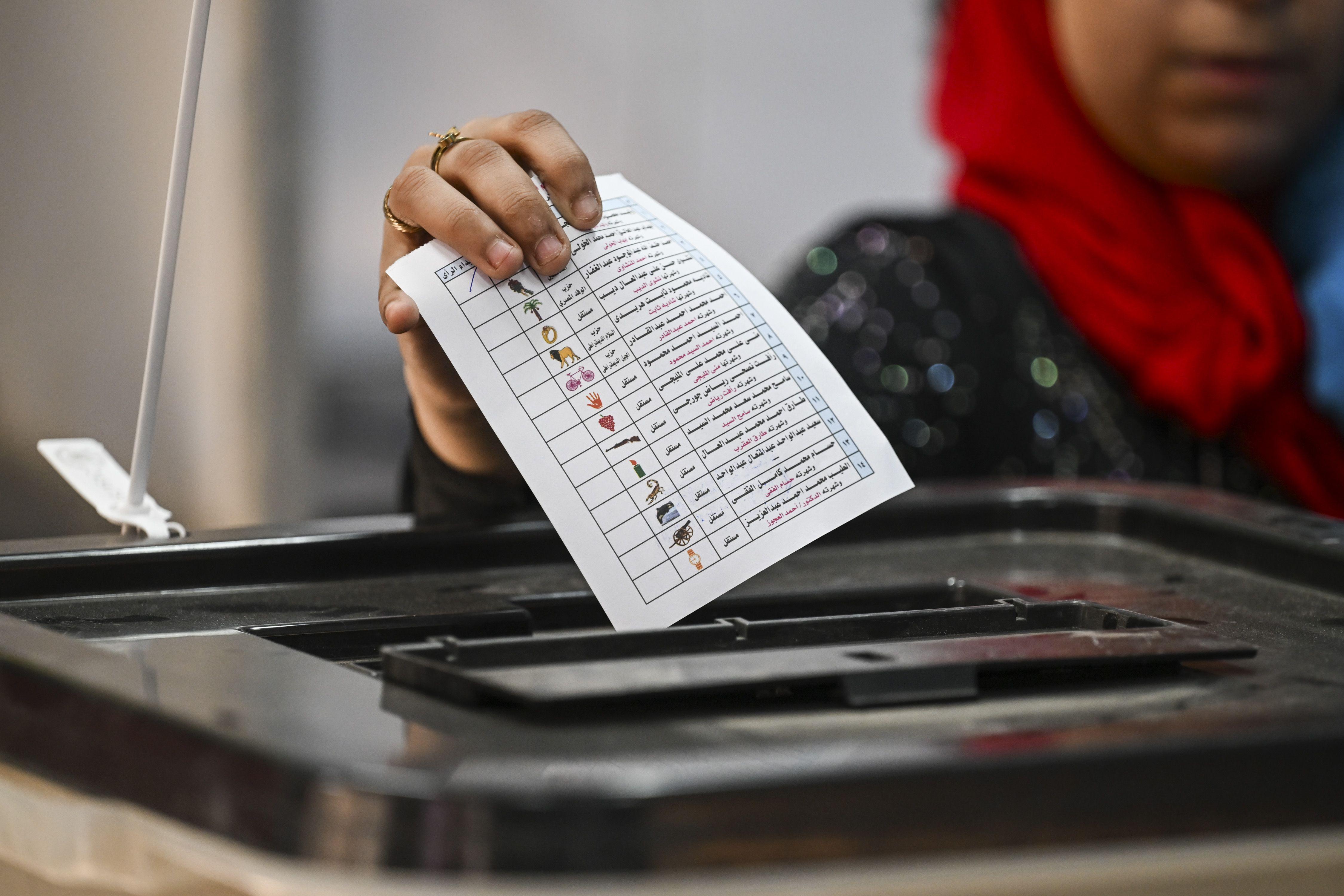 سيدة مصرية  تضع بطاقة انتخاب في الصندوق