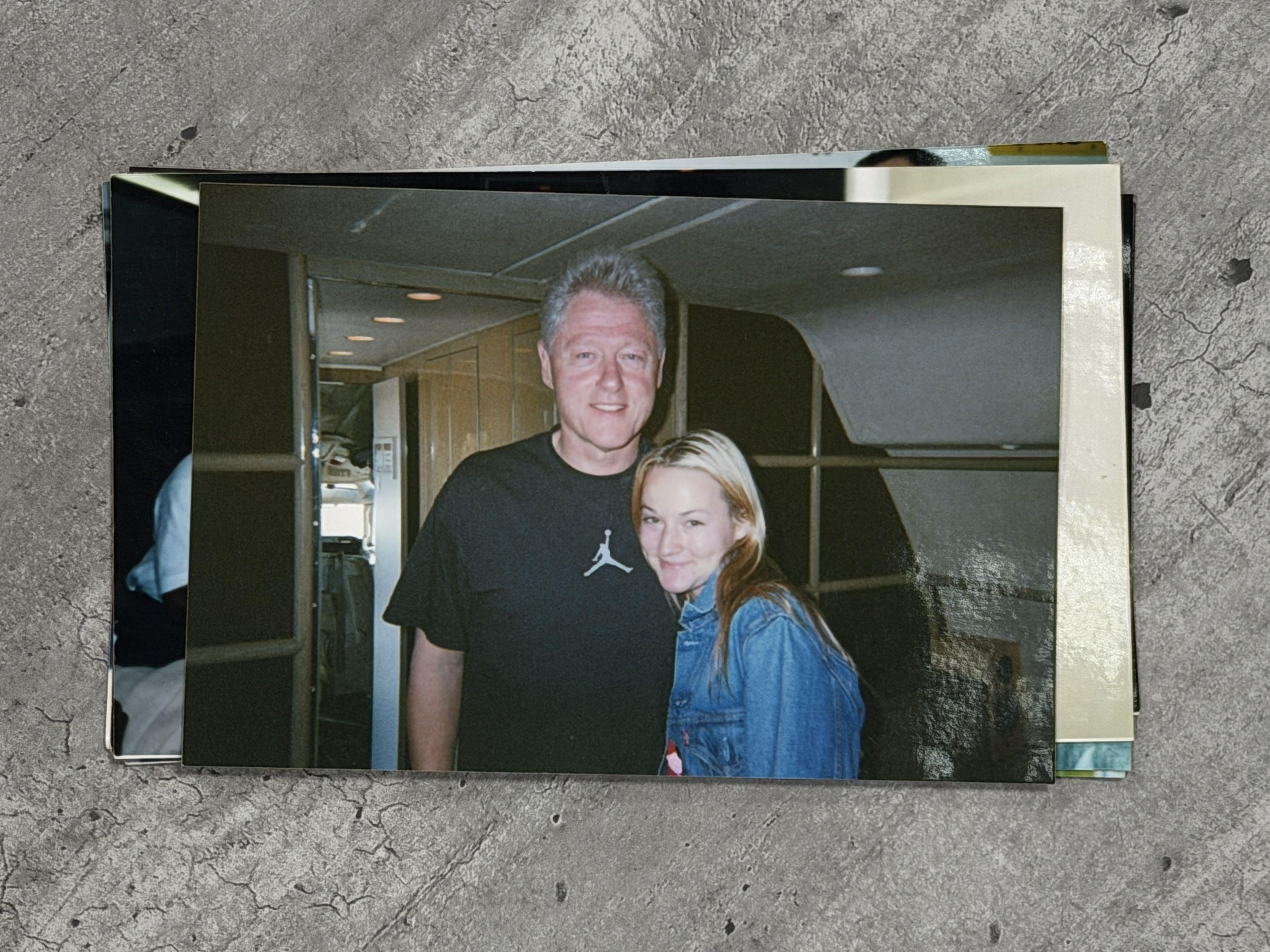 بيل كلينتون، رجل مسنّ ذو شعر رمادي قصير، يقف بالقرب من شابة تُدعى شونتاي ديفيز. ويرتدي كلينتون قميصاً أسود قصير الأكمام يحمل شعار 